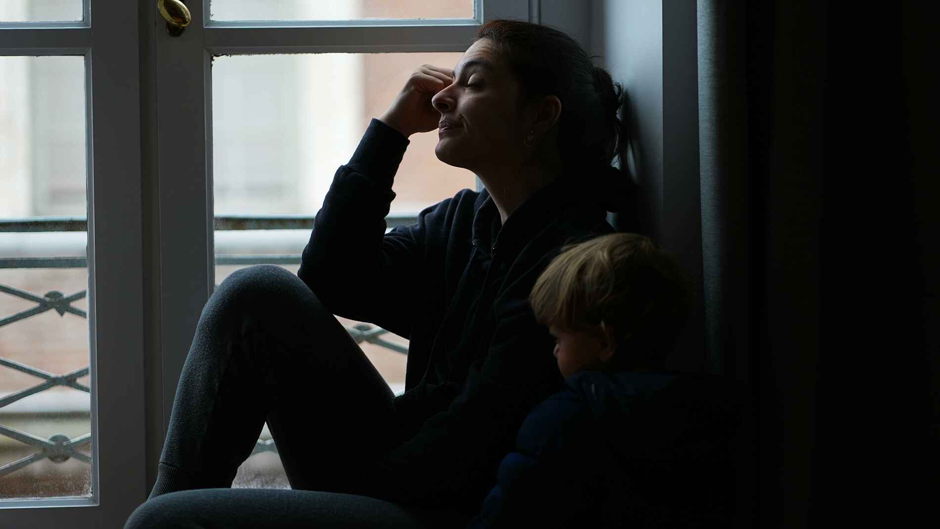 Woman sitting by window thinking. 