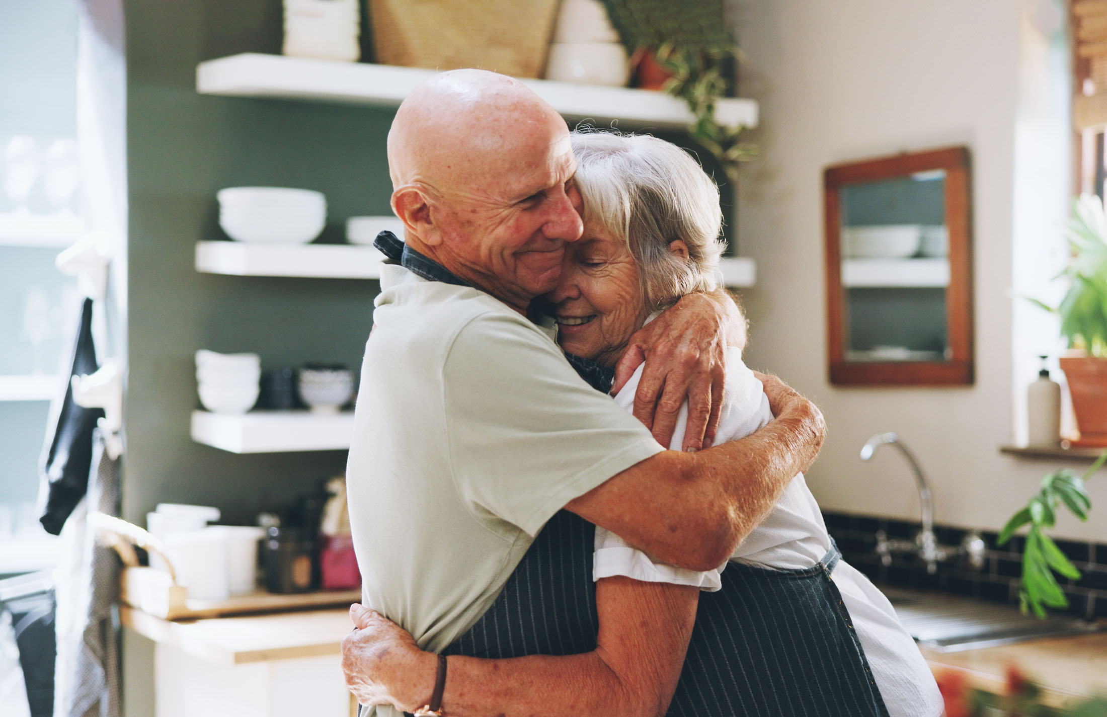 Two older people hugging. 