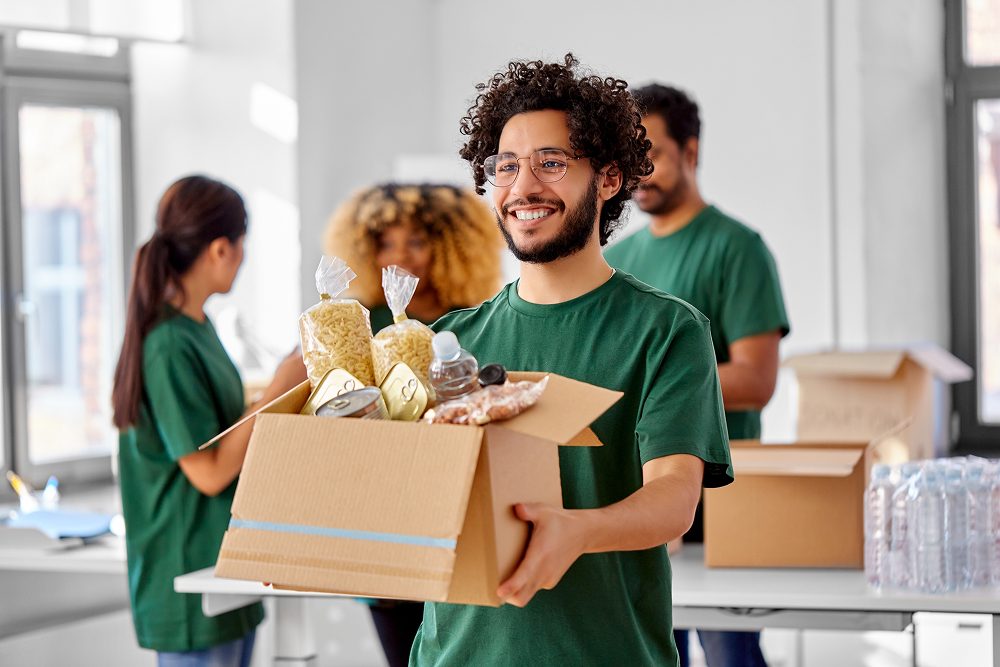 Volunteer holding a box of food. 