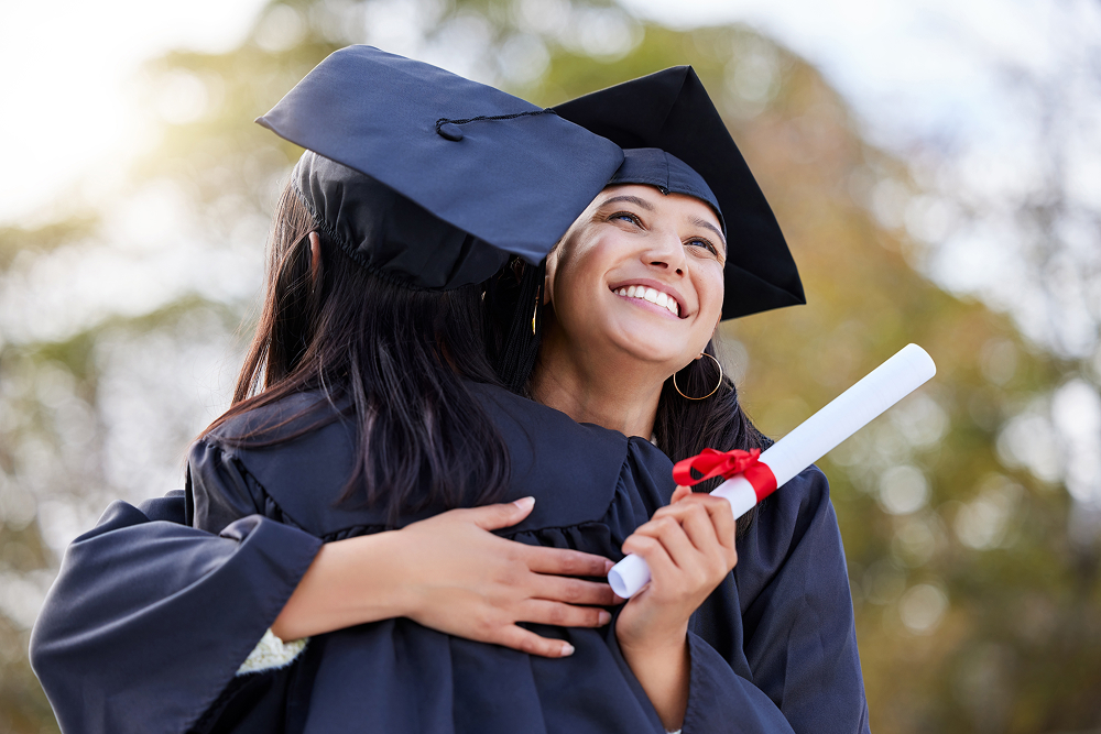 Two people in cap and gown graduating. 