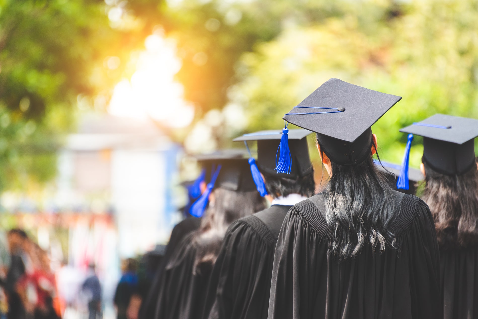 Graduates lined up with cap and gowns. 